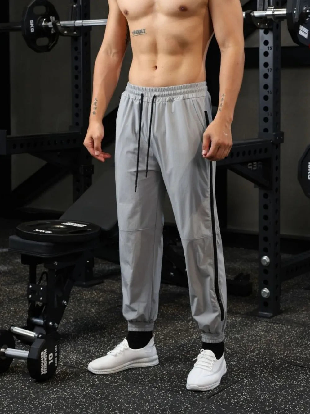 Gray track pants with black zip detail and drawstring waist.