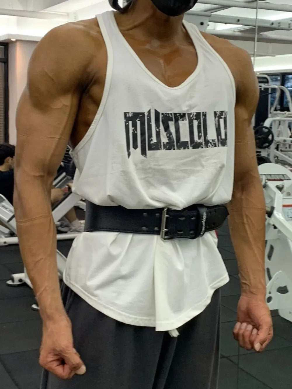 White muscle tank with distressed black logo graphic and a black weightlifting belt.