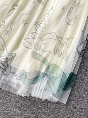 Off-white tulle skirt with whimsical abstract sunburst print and pleated hem.