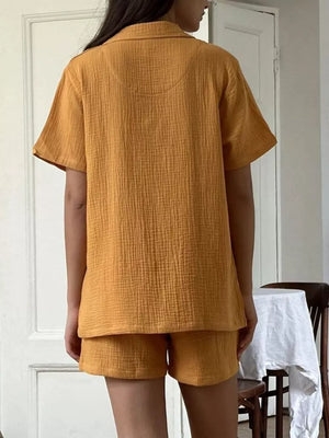 Yellow cotton pajama set with relaxed fit button-up shirt and shorts.