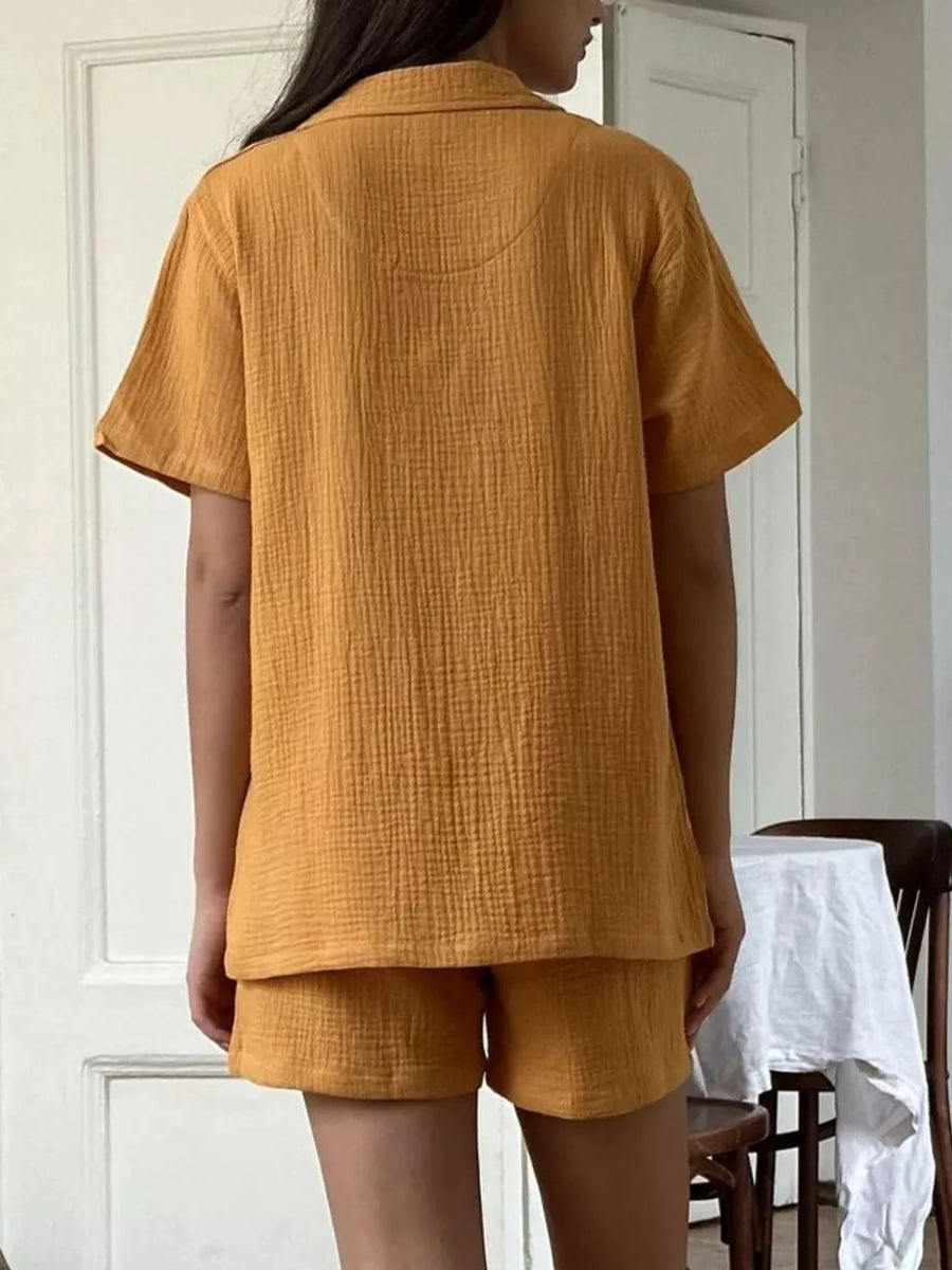 Yellow cotton pajama set with relaxed fit button-up shirt and shorts.