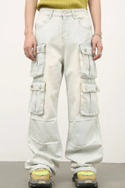 Light wash denim cargo pants with multiple pleated pockets and wide legs.