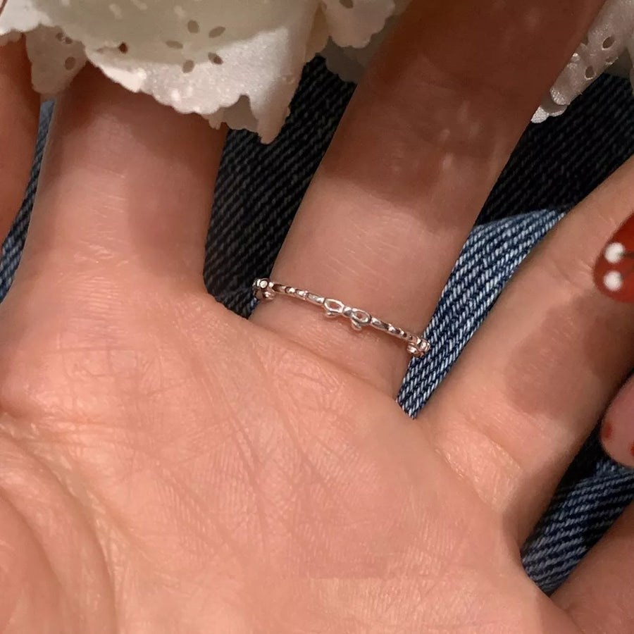 Delicate sterling silver ring with a dainty bow design.