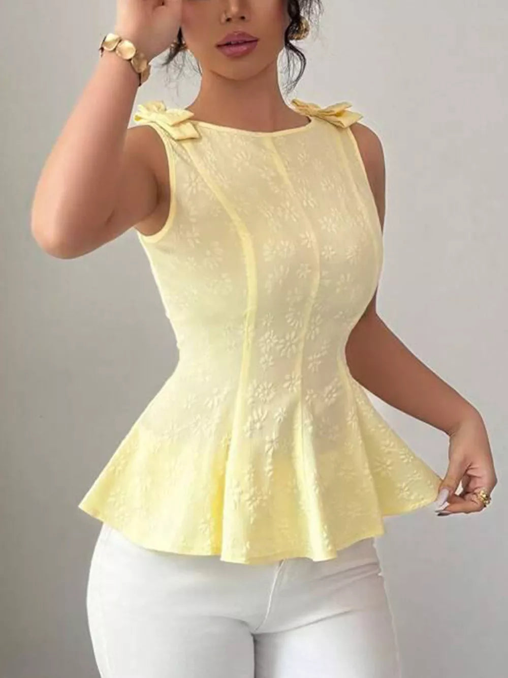 Yellow peplum tank top with embroidered floral pattern and bow shoulder details