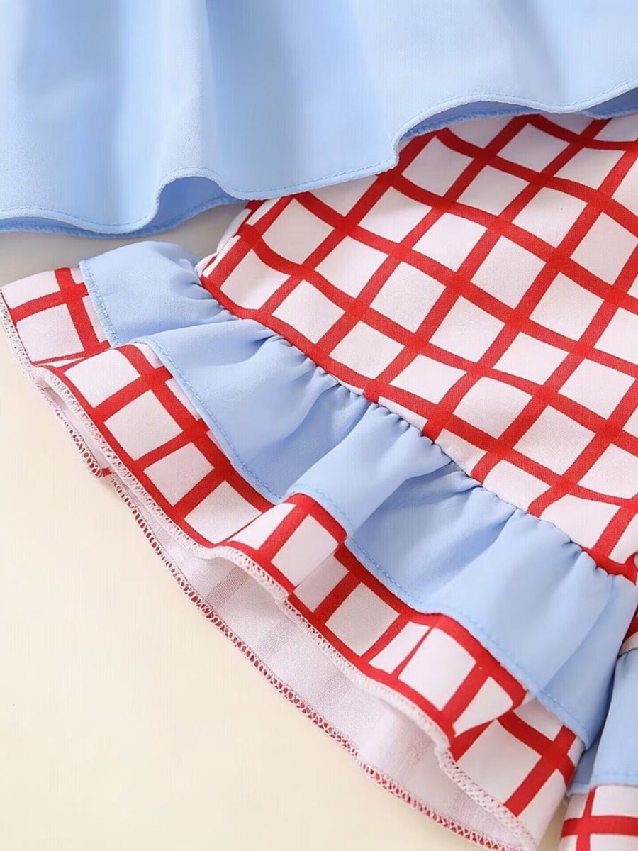 Baby girl's cotton set with blue ruffles and red checkered pattern.
