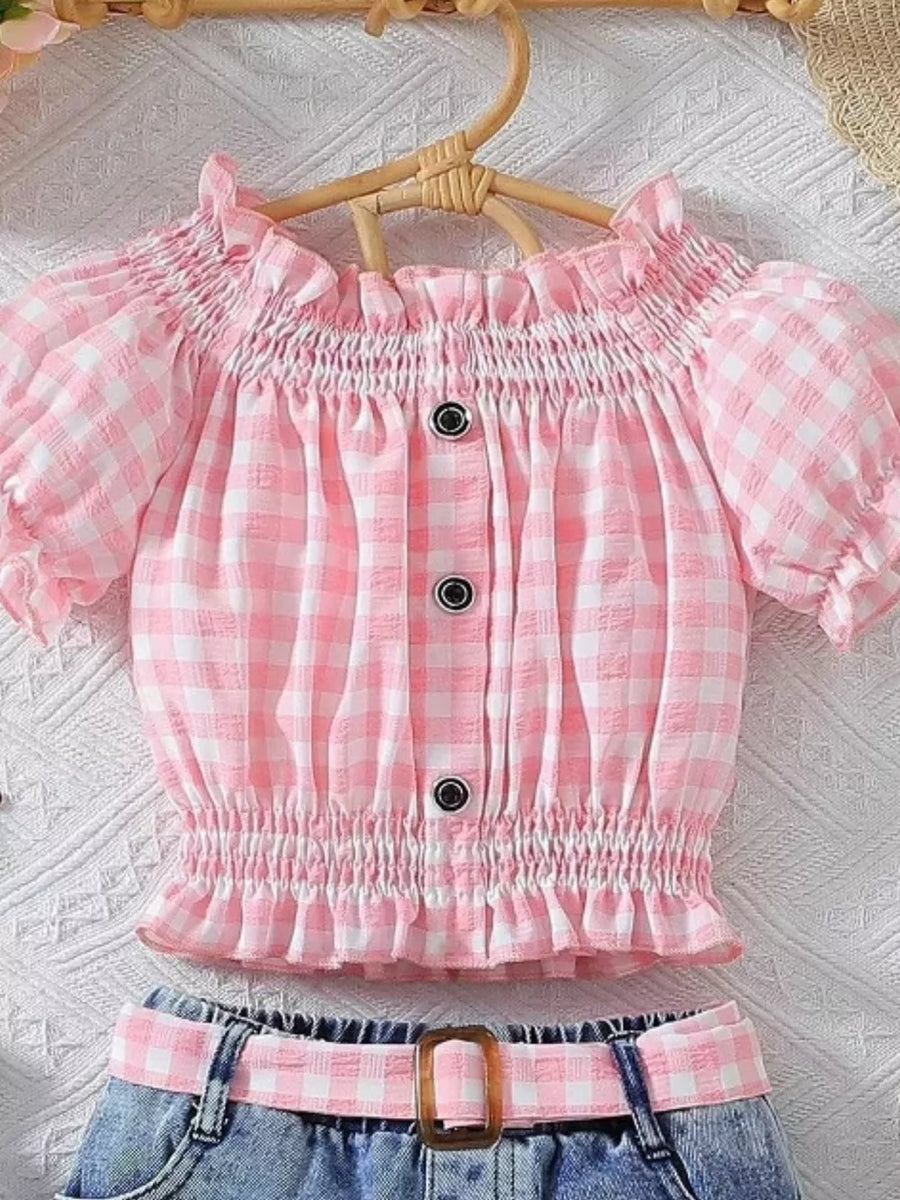Pink gingham baby top with smocked bodice and ruffled sleeves, paired with denim shorts and matching belt.
