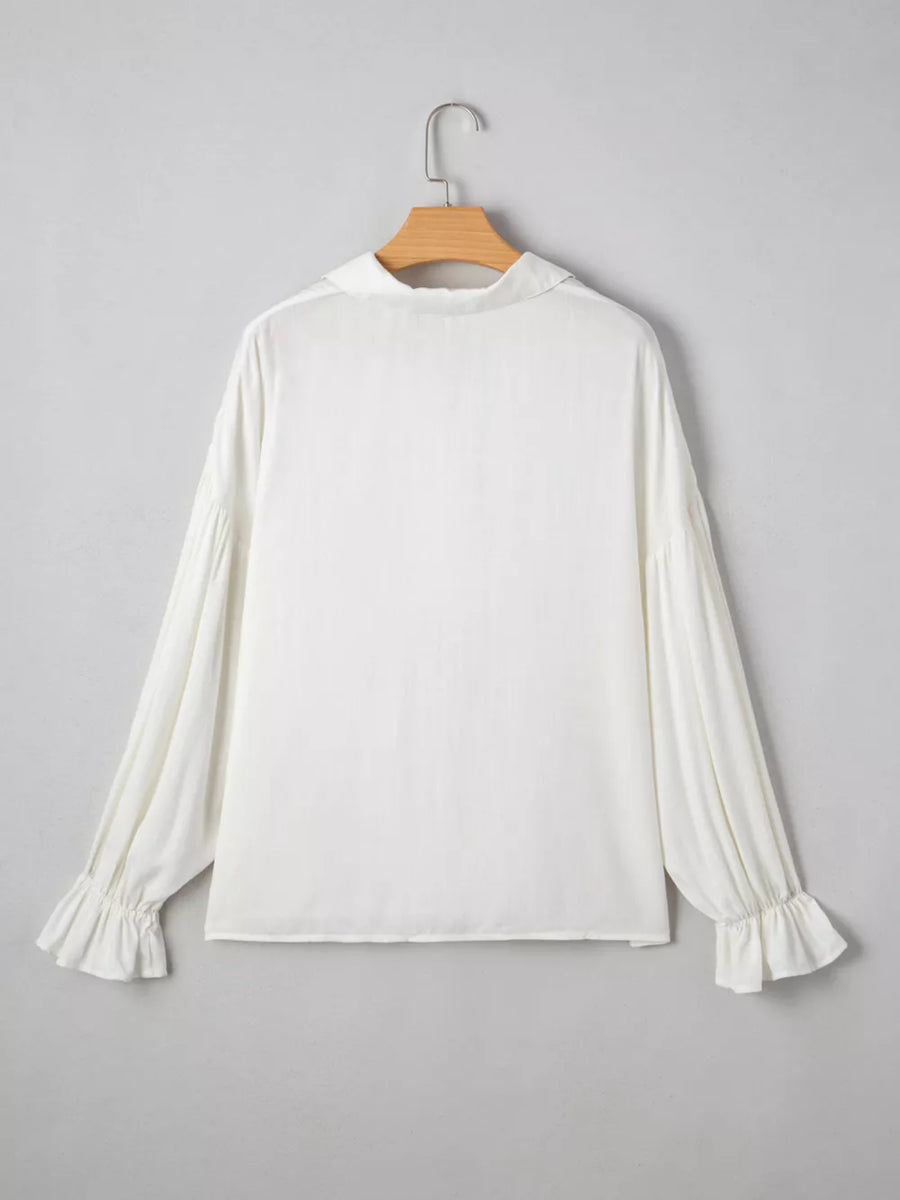 White long sleeve blouse with ruffled cuffs and collar