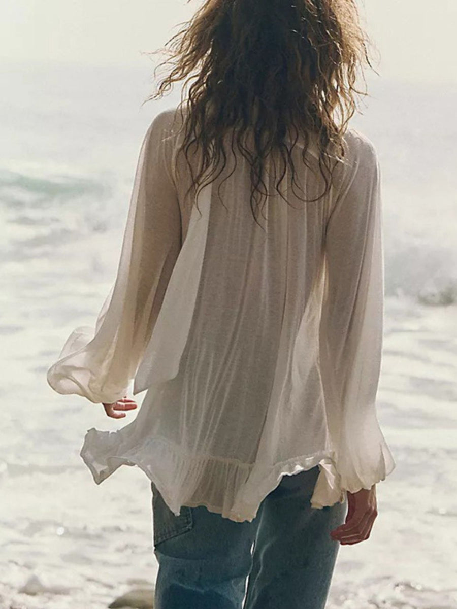 White sheer ruffle trim beach cover-up with long flowy sleeves and a ruffled hem.