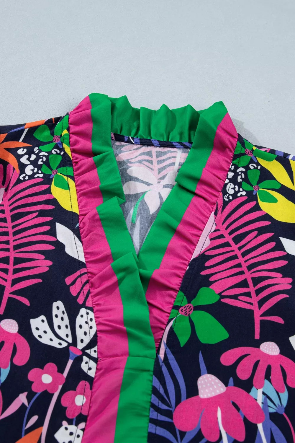 Floral frill v-neck shirt with striped accents and colorful tropical print.