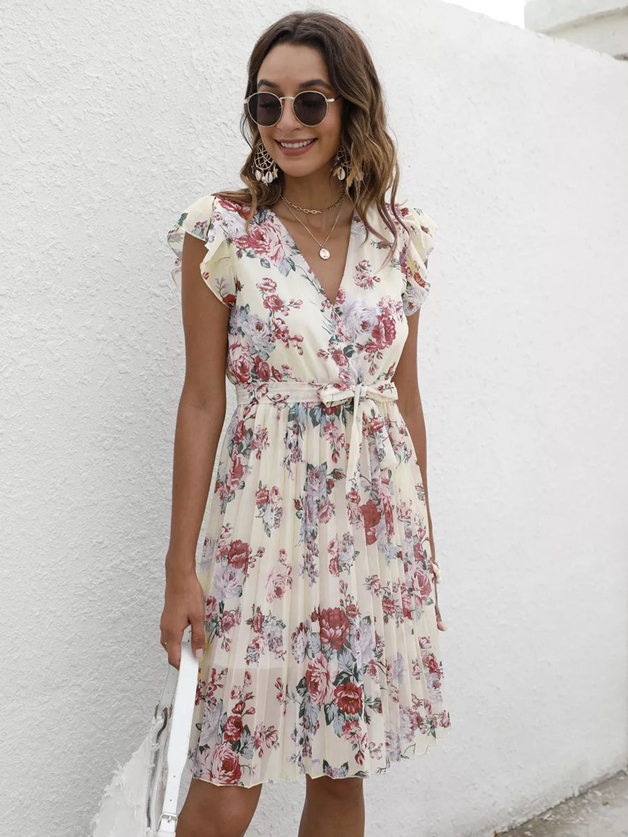 Cream floral pleated wrap dress with ruffle sleeves and a tie belt.