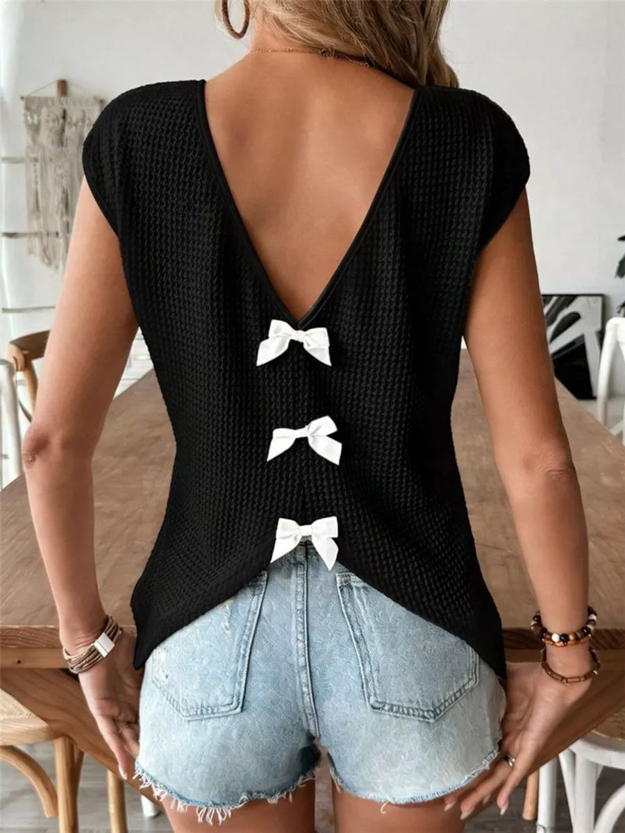 Black waffle knit V-neck shirt with cap sleeves and three white bow details down the back.