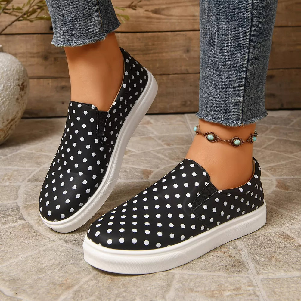 black slip-on shoes featuring elastic goring and polka dot