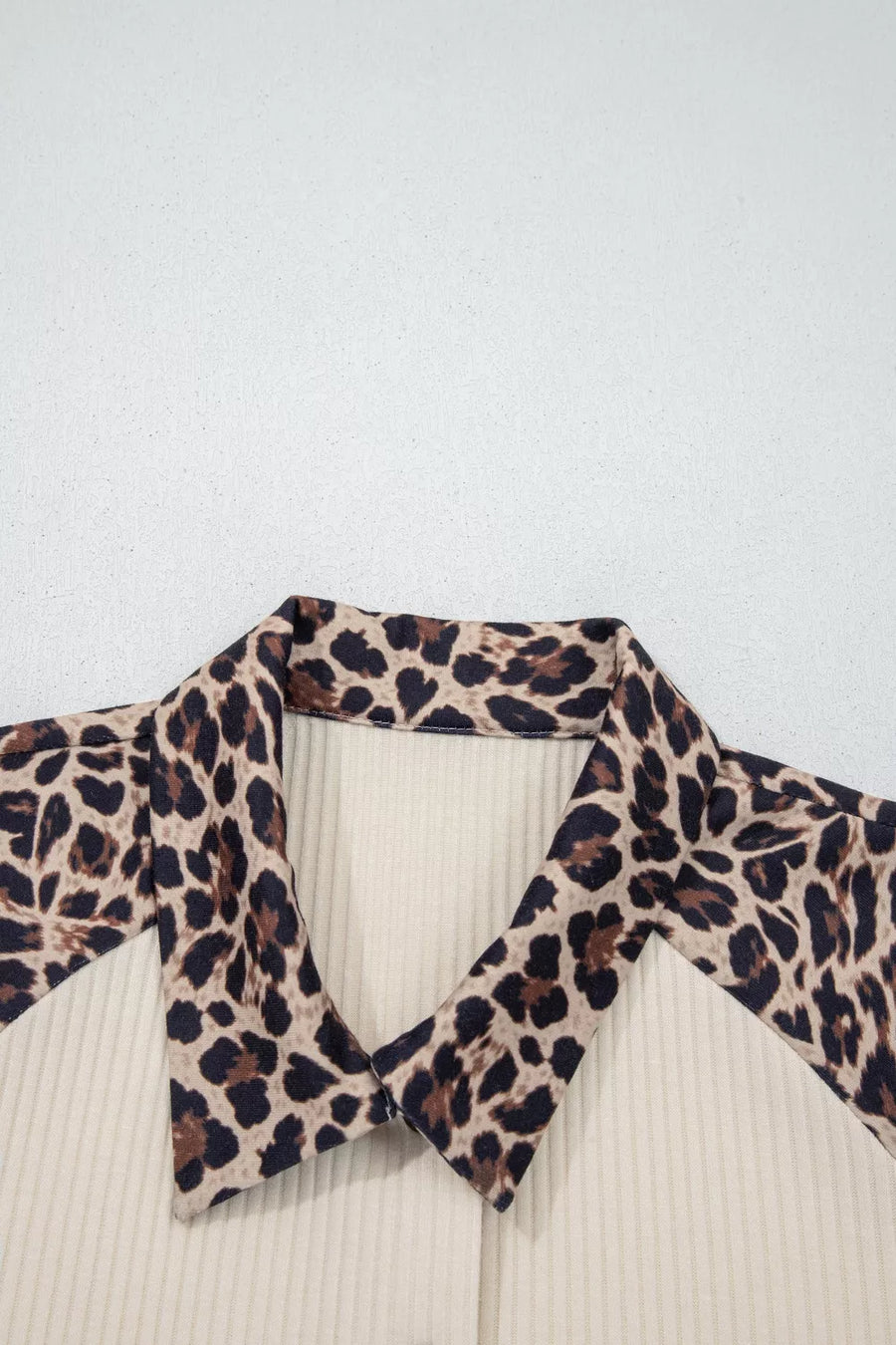 Ribbed cream shirt with leopard print collar and lapels.