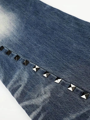 Blue distressed bootcut jeans with a row of silver pyramid studs along the seam.