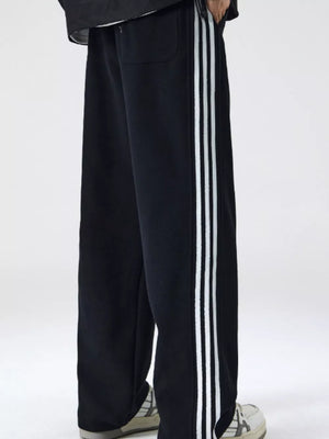 Black men's sweatpants with white side stripes and a relaxed fit.
