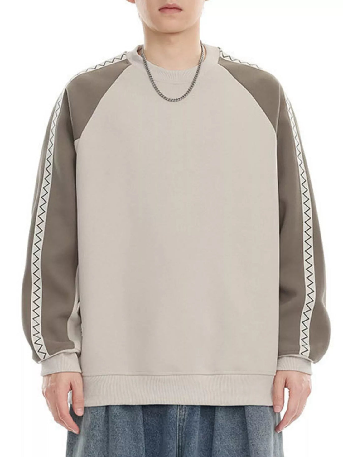 Oversized raglan sleeve sweatshirt in beige and gray with zigzag trim detail.