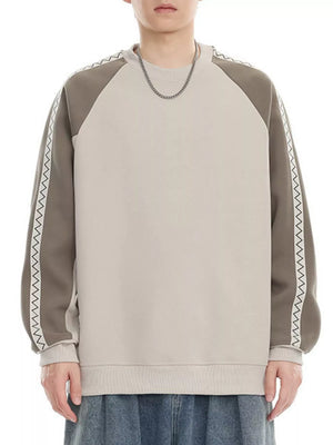 Oversized raglan sleeve sweatshirt in beige and gray with zigzag trim detail.