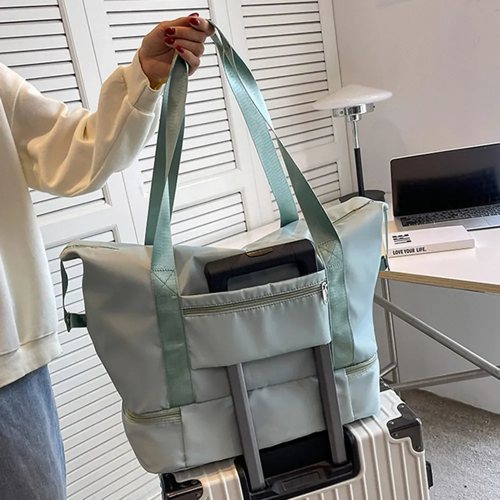 Pale blush dual-compartment travel tote with metallic trim and zippered pocket.