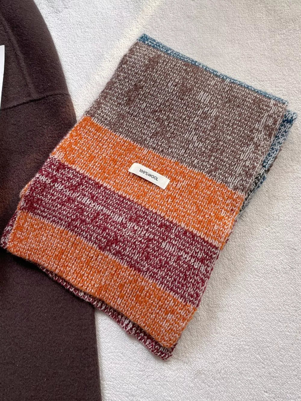 Textured wool color block scarf with orange, burgundy, and brown stripes.