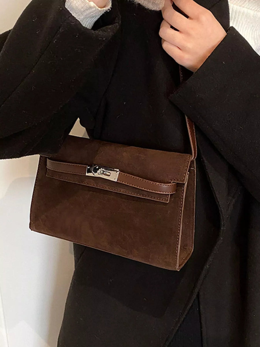 Brown suede shoulder bag with silver buckle detail and leather strap.
