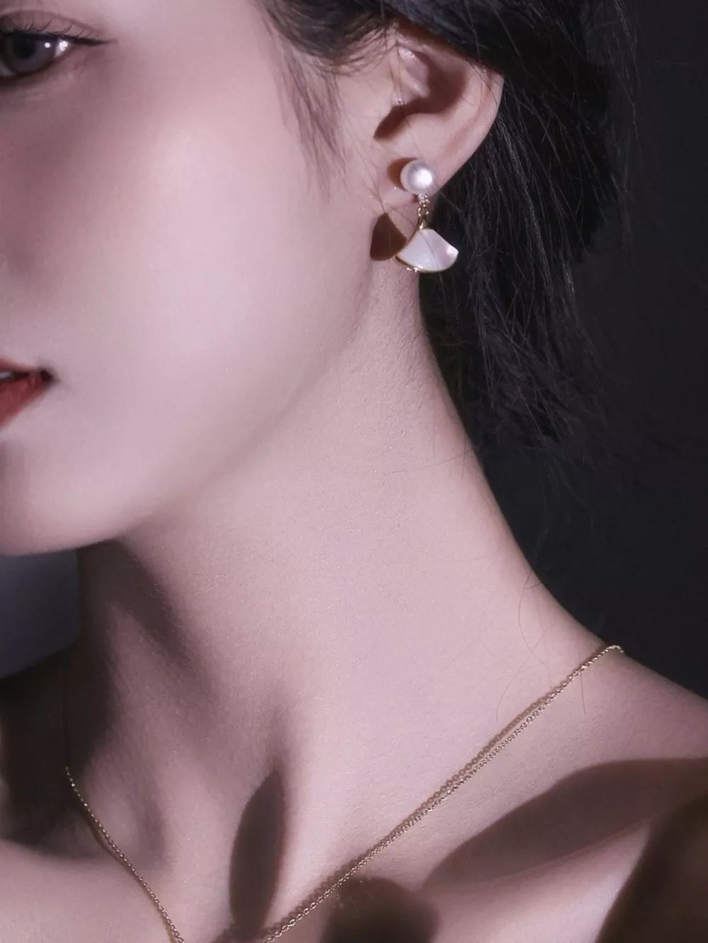 Elegant fan-shaped pearl earrings with mother-of-pearl detail.