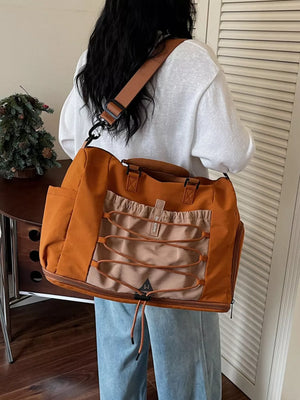 Large orange nylon duffel bag with bungee cord detail and tan accents.