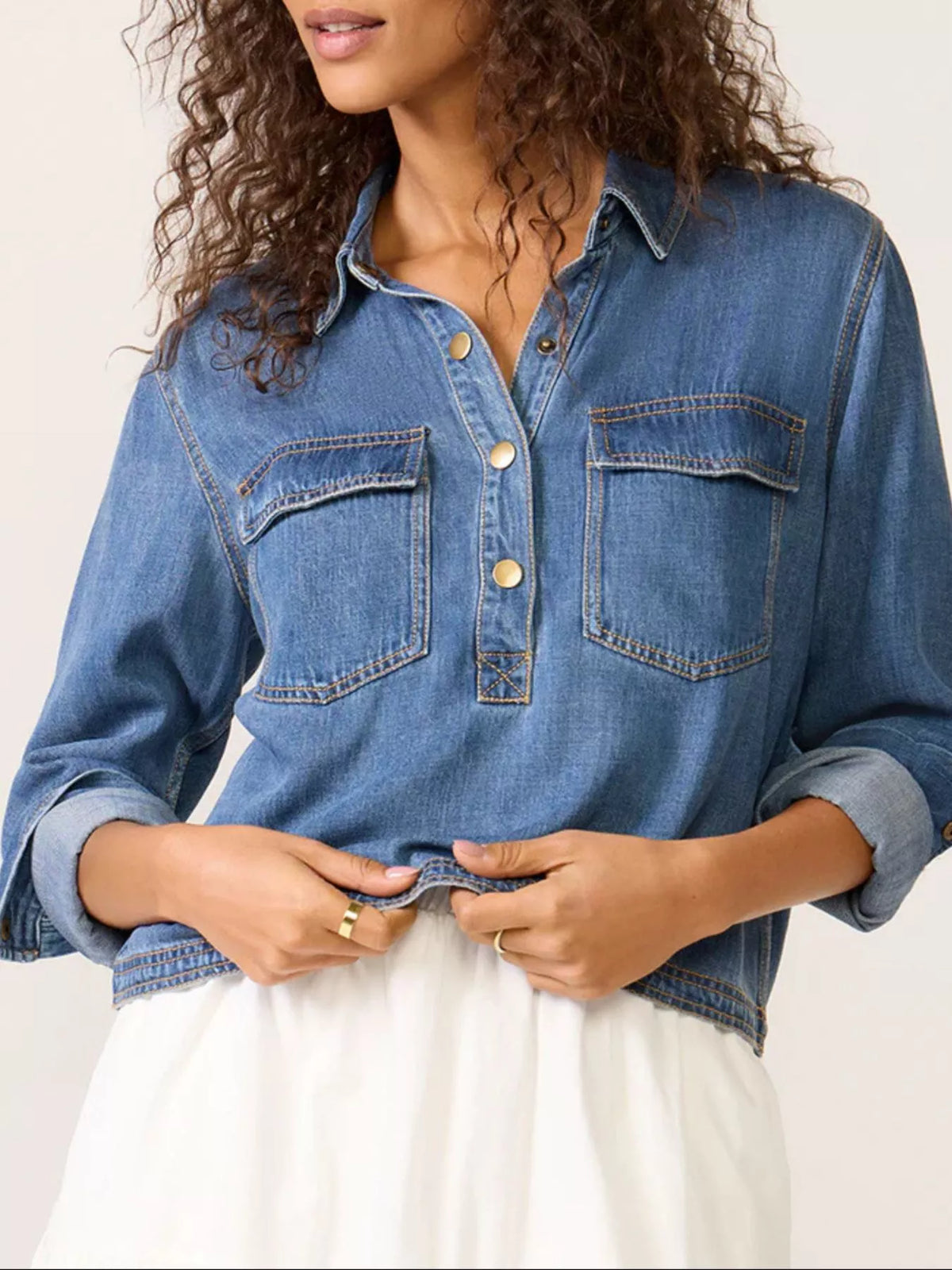 Blue denim cropped half snap shirt with collar and chest pockets.