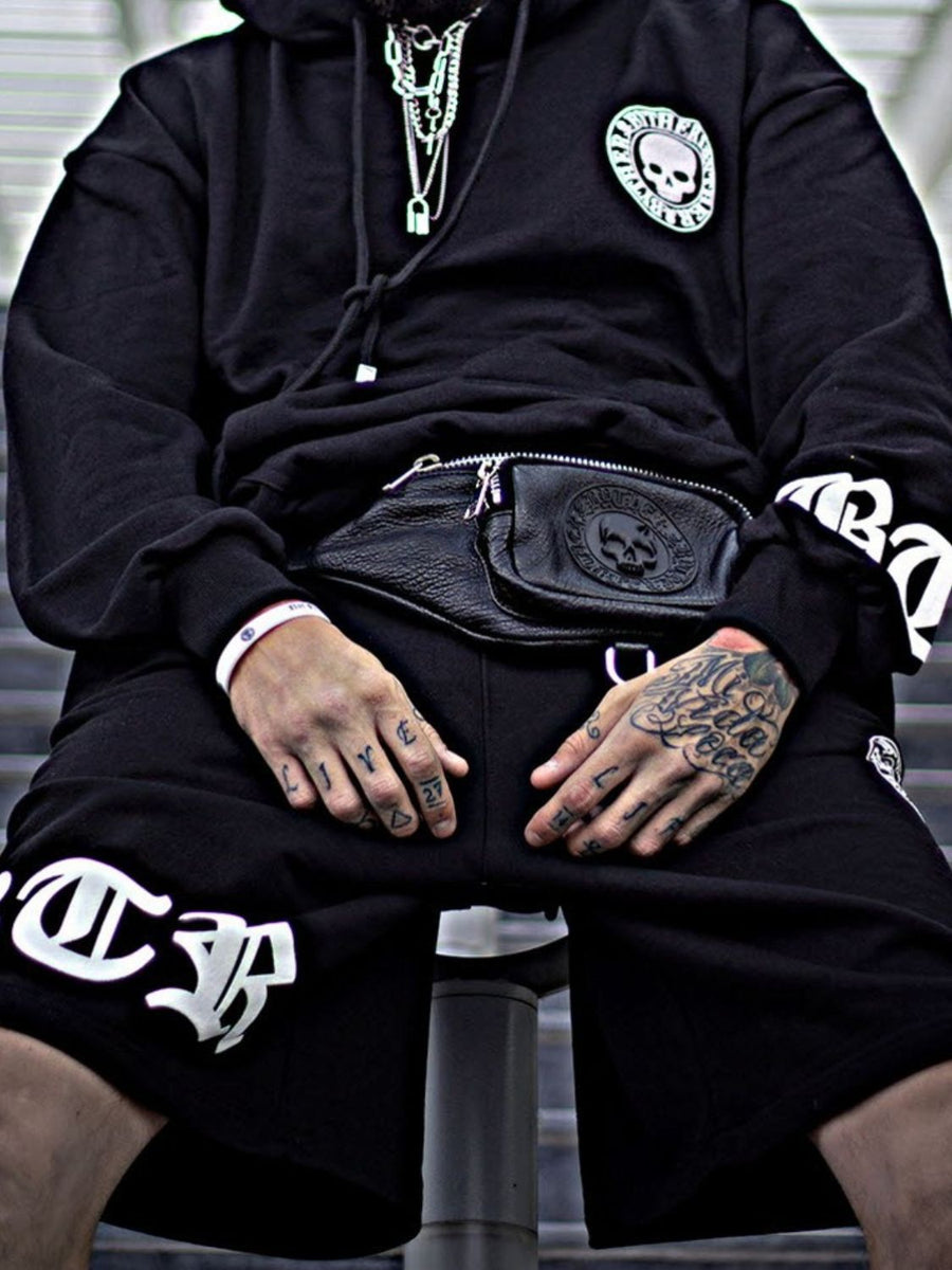 Black hoodie with skull patch and white graphic shorts