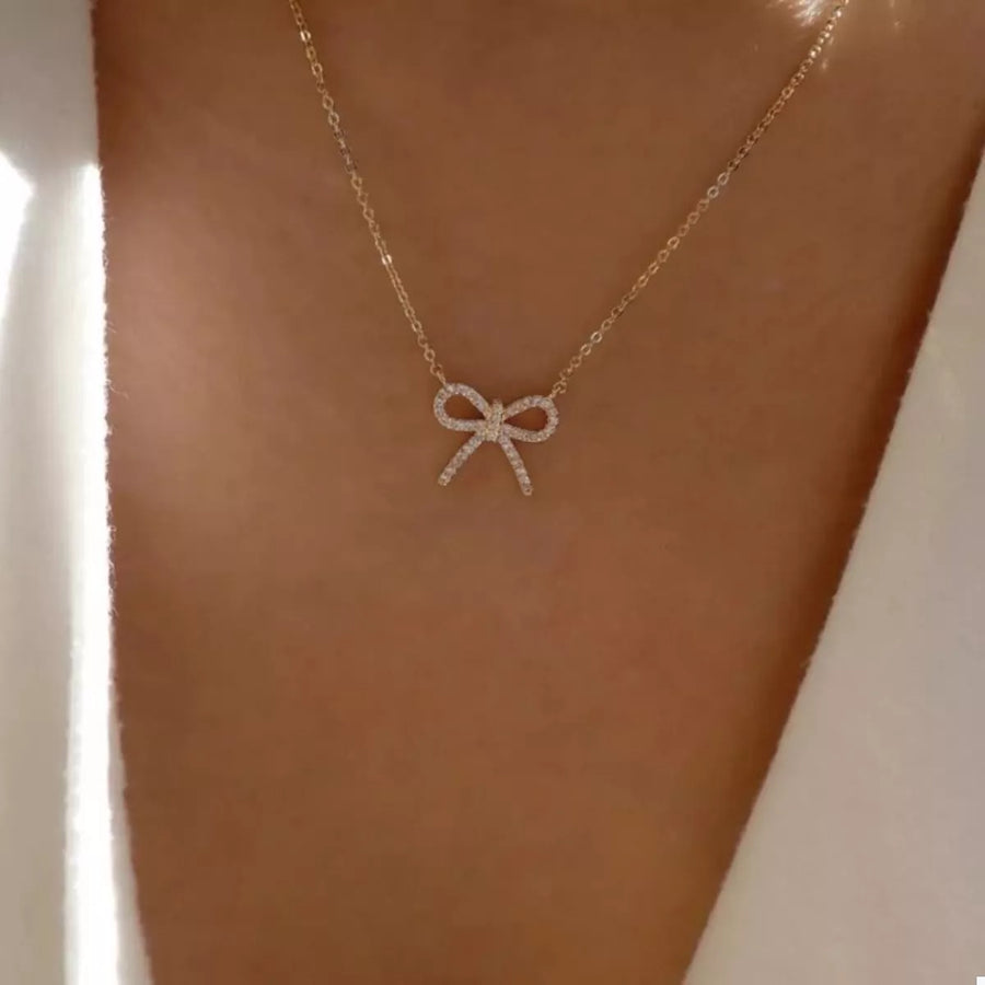 Gold bowknot pendant necklace with clear stones on a delicate chain