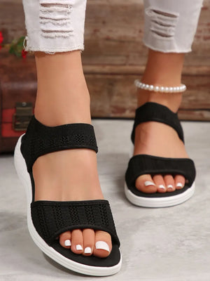 Black mesh peep toe sandals with white soles and elastic straps.