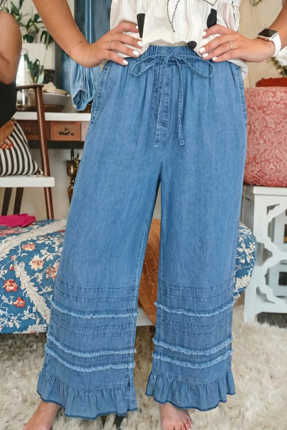 Maternity wide-leg chambray jeans in light wash denim with ruffled hem detail and drawstring waist.