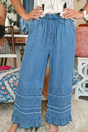 Maternity wide-leg chambray jeans in light wash denim with ruffled hem detail and drawstring waist.