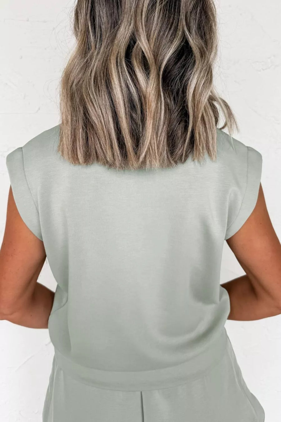 Light green activewear set with padded shoulders and banded hem.