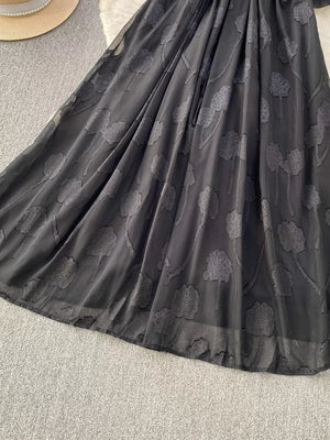 Black chiffon maxi dress with allover floral embroidery and a belted waist.