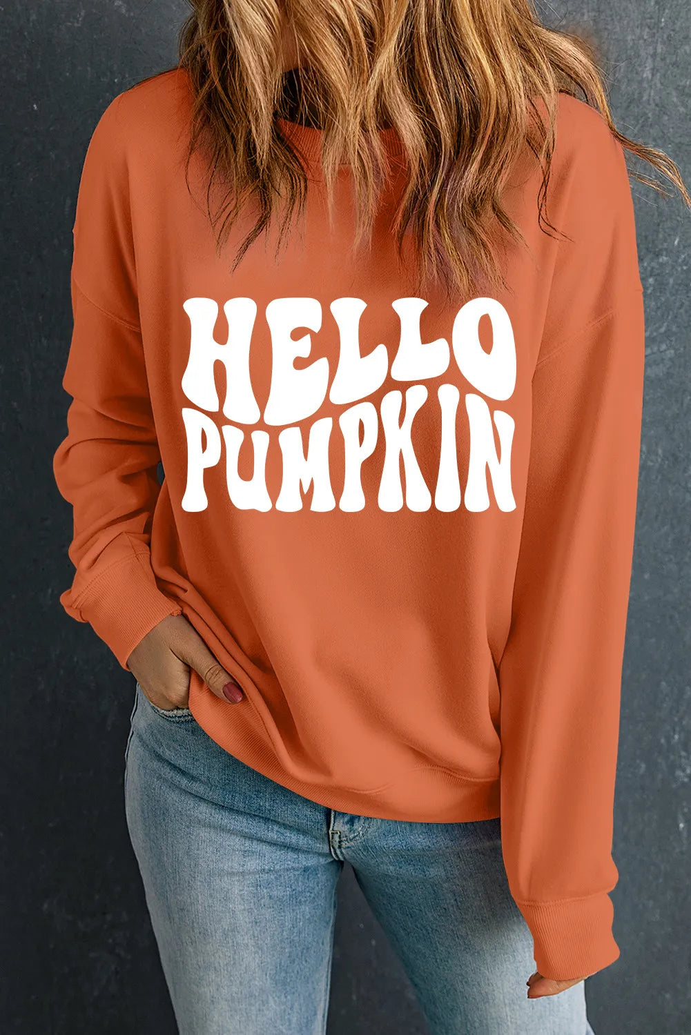 Orange graphic print sweatshirt with round neck and long sleeves.