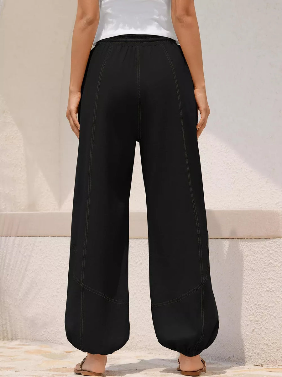 Black relaxed harem pants with drawstring detail and contrast stitching