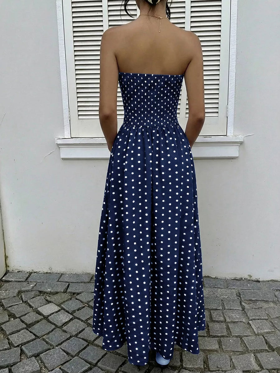 Navy polka dot strapless A-line maxi dress with smocked bodice.