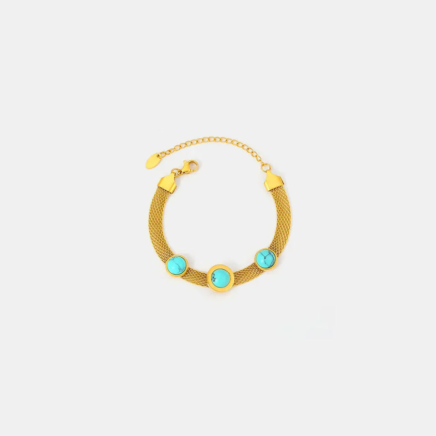 Gold mesh bracelet with three turquoise stones and Roman numerals.