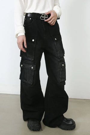 Oversized dark denim cargo pants with multiple buttoned pockets and a wide leg.