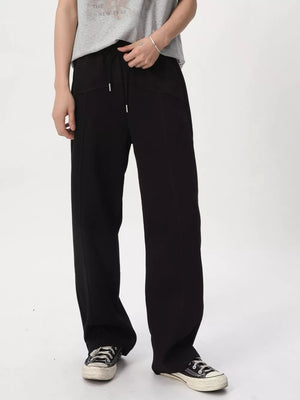 Black cotton drawstring sweatpants with a wide-leg cut and tailored seams.