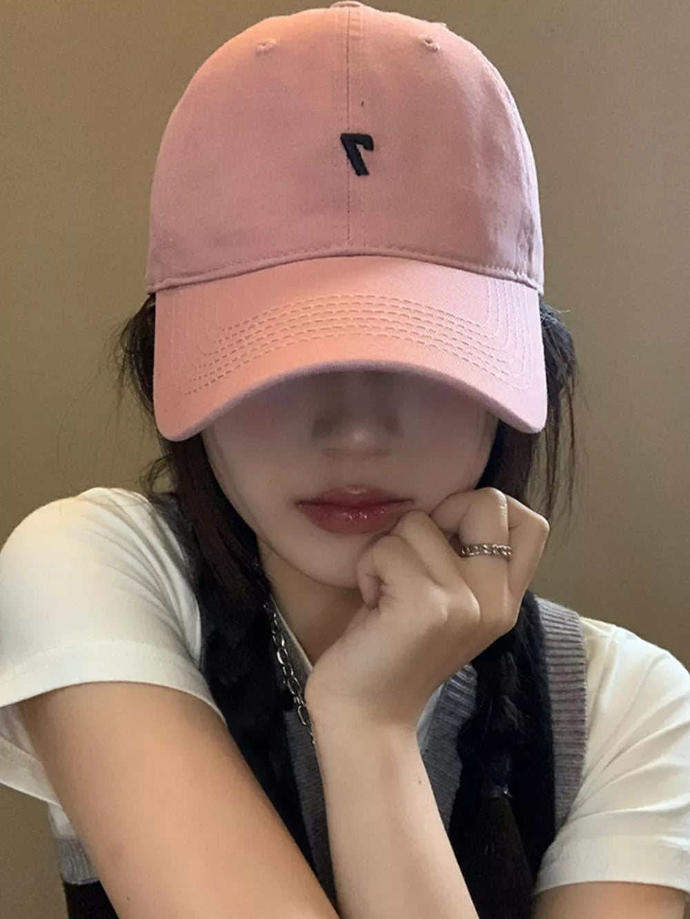 Pink cotton baseball cap with black embroidered detail and curved brim