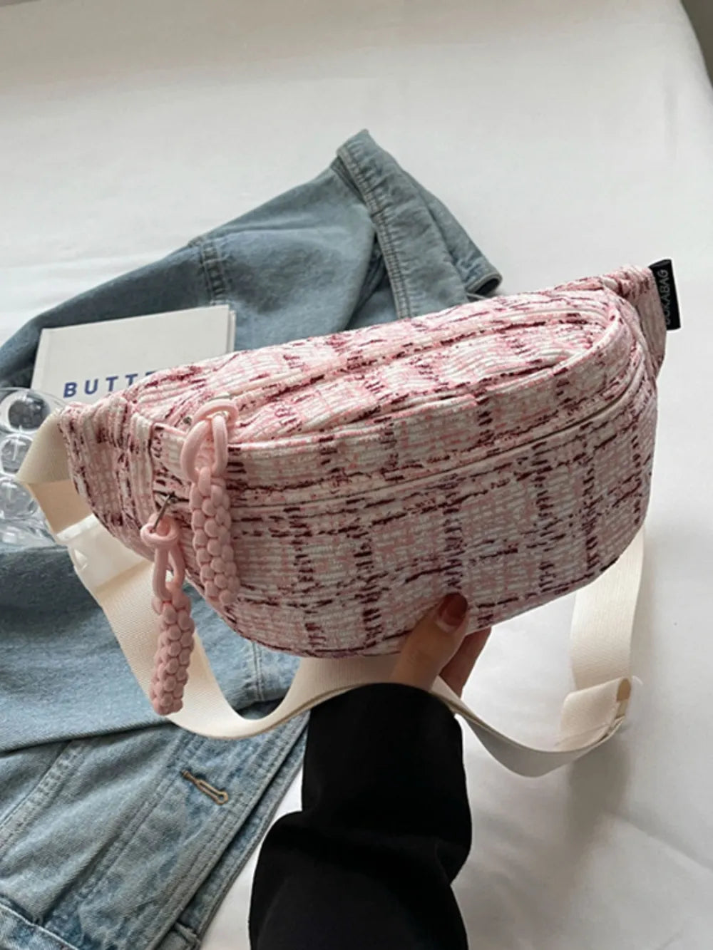 Pink textured tweed belt bag with braided pulls and white strap