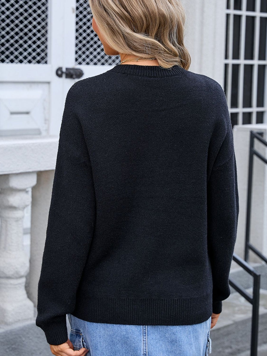 Black acrylic knit sweater with crew neck and long sleeves, featuring a subtle bow motif detail.