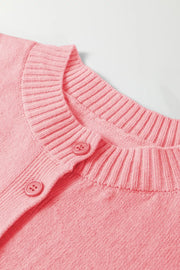 Pink acrylic knit cardigan with ribbed crew neck and button front detail