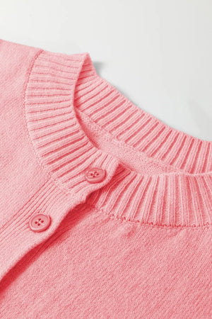 Pink acrylic knit cardigan with ribbed crew neck and button front detail