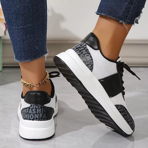 White and black lace-up sneakers with mesh detailing and text print accents.
