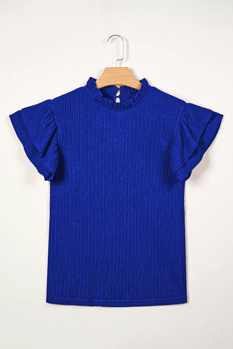 Blue textured short sleeve shirt with ruffle trim and mock neck.