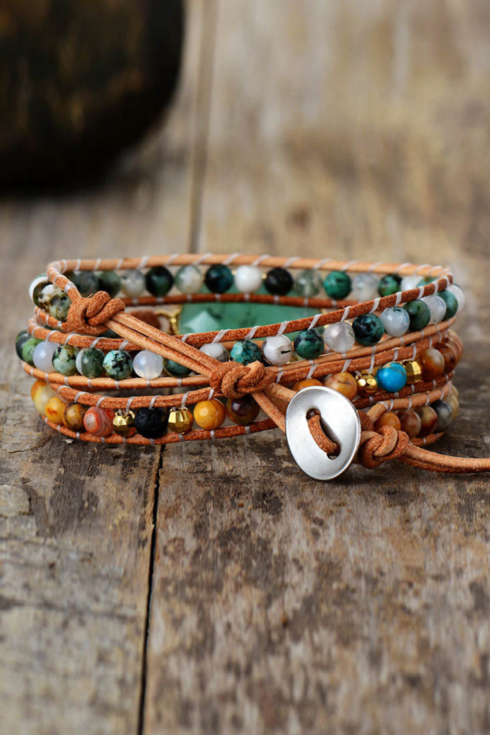 Wrap-around leather bracelet with light green agate and mixed stone beads, featuring a silver button closure.