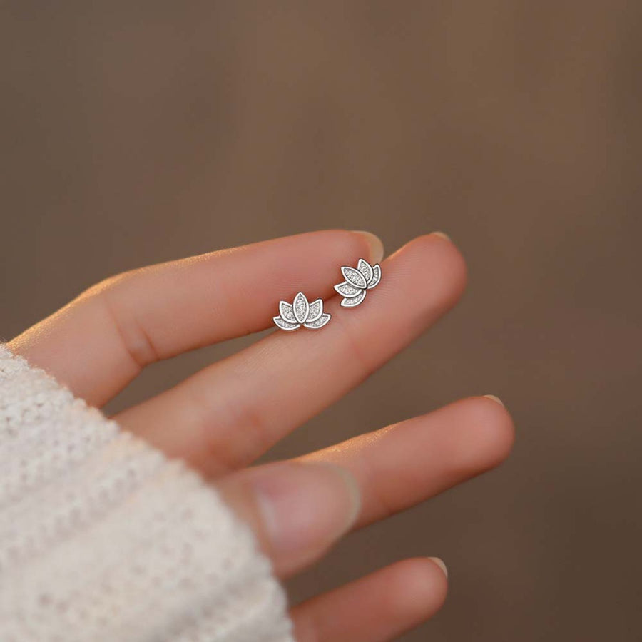 Silver lotus flower stud earrings with delicate crystal accents.