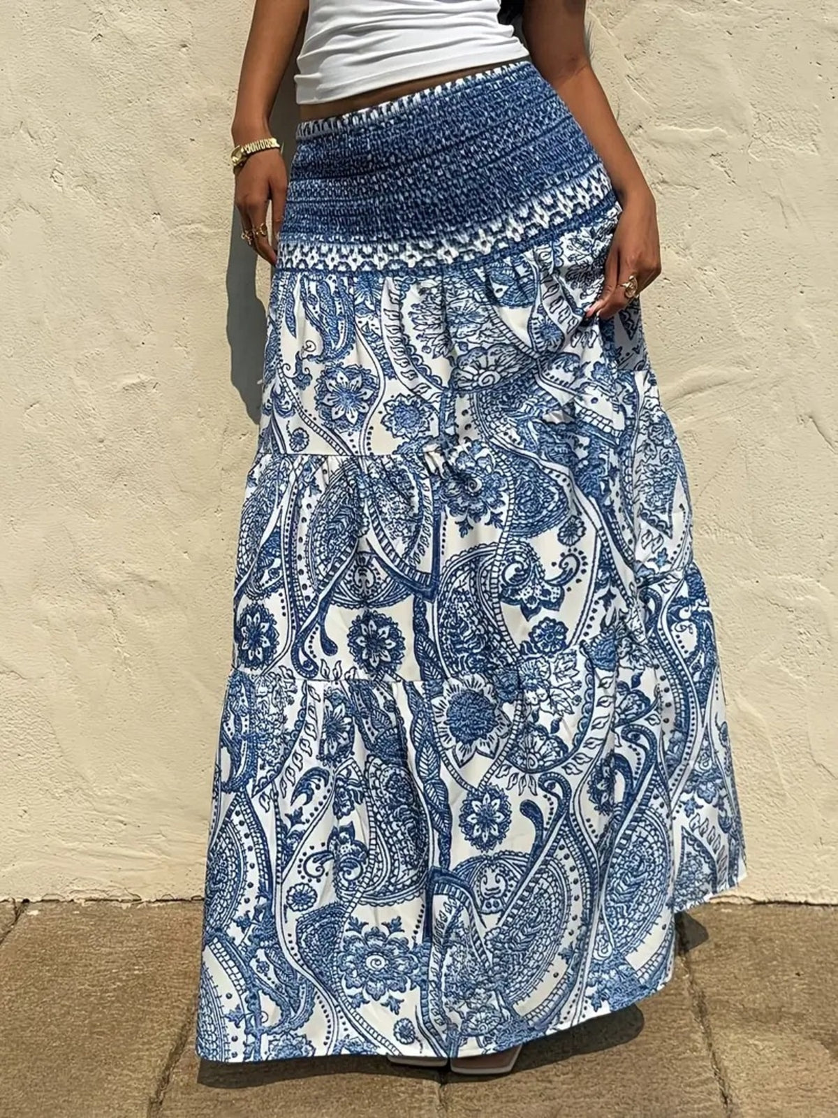 Bohemian maxi skirt in blue paisley print with smocked waist and tiered ruffles.